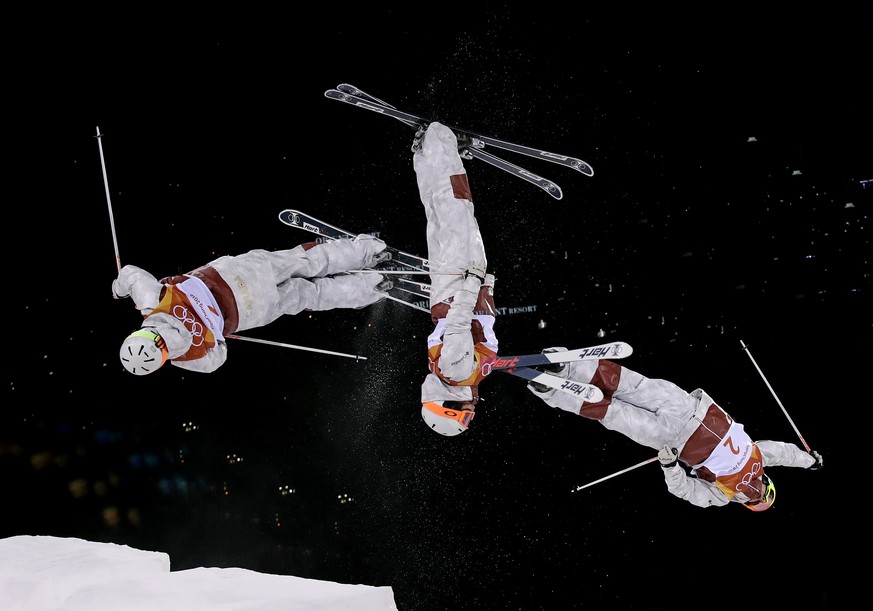 In this multiple exposure photo, Andi Naude, of Canada, jumps during the women&#039;s moguls finals at Phoenix Snow Park at the 2018 Winter Olympics in Pyeongchang, South Korea, Sunday, Feb. 11, 2018. ...