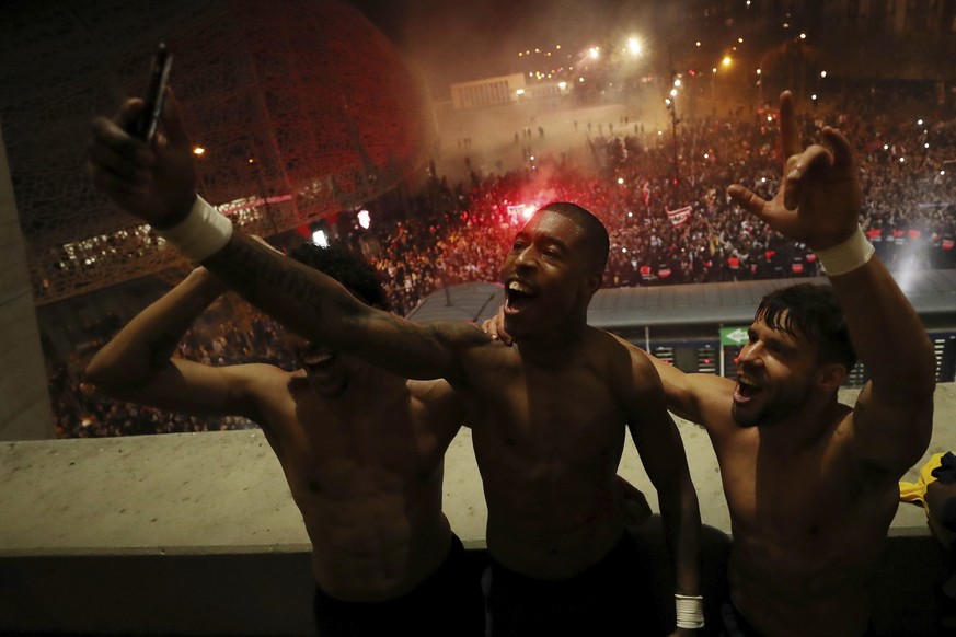 Paris Saint Germain&#039;s Presnel Kimpembe, center, and Juan Bernat, right, celebrate the victory after the Champions League round of 16 second leg soccer match between PSG and Borussia Dortmund, Wed ...