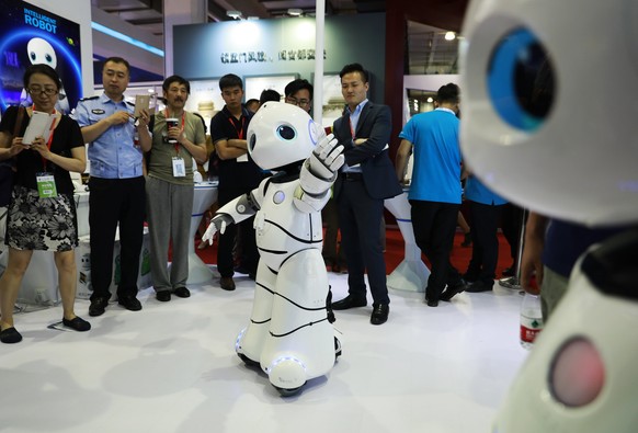 epa06016291 Visitors look at robots on display at the China Beijing International High-Tech Expo (CHITEC) in Beijing, China, 08 June 2017. The 20th edition of the China Beijing International High-Tech ...