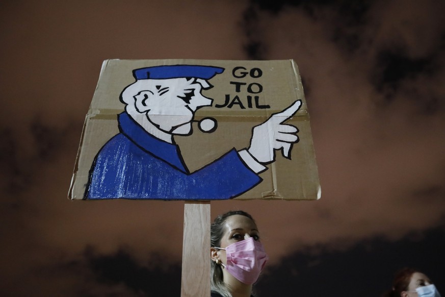 Israeli protesters hold a banner during a demonstration against coronavirus lockdown measures that protesters believe are aimed at curbing protests against Prime Minister Benjamin Netanyahu, in Tel Av ...