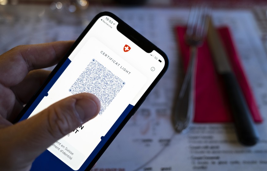 Une personne tient dans sa main un smartphone avec l'application Certifact Covid suisse et un certificat light dans un restaurant ce vendredi 10 septembre 2021 a Rances dans le canton de Vaud. Des ce  ...