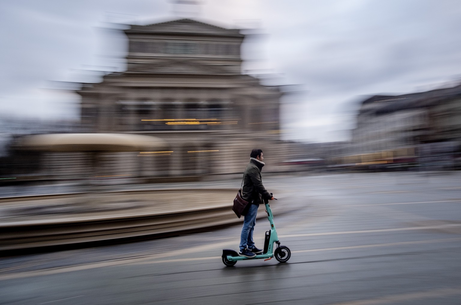 A man rides an E-scooter to work in front of the Old Opera in Frankfurt, Germany, early Monday, Feb. 12, 2024. (AP Photo/Michael Probst)