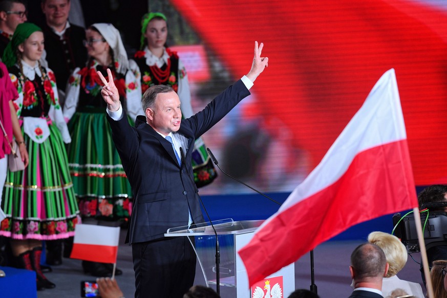 epa08514997 Incumbent President and candidate of the ruling right-wing Law and Justice (PiS) party, Andrzej Duda, celebrates with supporters after learning from the initial projections that he appears ...