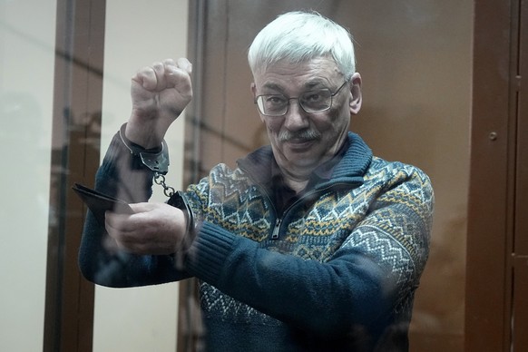 FILE The co-chair of the Nobel Peace Prize winning Memorial Human Rights Centre Oleg Orlov gestures standing in a glass cage after he was taken into custody in the courtroom during court session for a ...