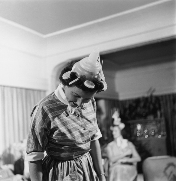 A suitably-attired woman attends a Tupperware party, hosted to market the new brand of plastic containers, circa 1955. (Photo by Gould/Archive Photos/Getty Images)
