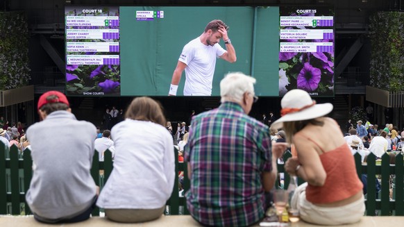 Spectators on Murray Mound (also known as &quot;Henman Hill&quot;) watch Stan Wawrinka of Switzerland on a big screen during his second round match against Reilly Opelka of USA, at the All England Law ...