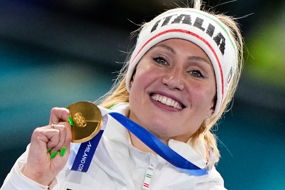 Francesca Lollobrigida of Italy shows her gold medal on the podium after the women's 5,000 meters speedskating race at the 2026 Winter Olympics, in Milan, Italy, Thursday, Feb. 12, 2026. (AP Phot ...