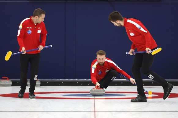Gli atleti della squadra nazionale svizzera di curling, Yannick Schwaller, al centro, Sven Michel, a sinistra, e Pablo Lachat, in azione durante una sessione di allenamento dopo un incontro con i media nella sala di curling...