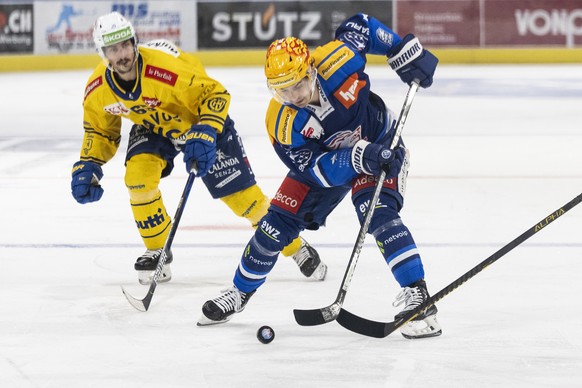 Davos&#039; Marc Wieser, links, kaempft um den Puck gegen Zuerichs PostFinance Top Scorer Denis Malgin, rechts, im Eishockeyspiel der National League zwischen den ZSC Lions und dem HC Davos am Diensta ...