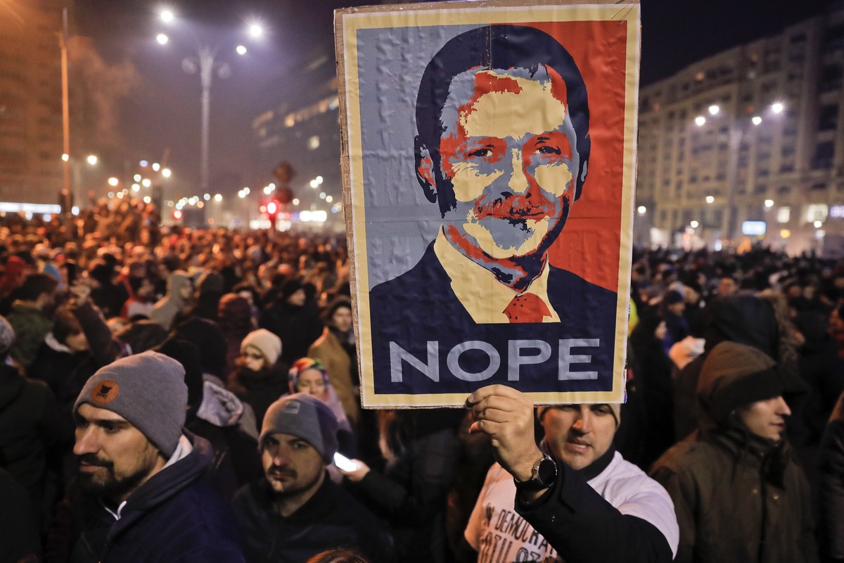In this photo taken on Tuesday, Jan. 31, 2017, a man holds a poster depicting the leader of the ruling Social Democratic party Liviu Dragnea, during a protest in Bucharest, Romania. Romania's gov ...