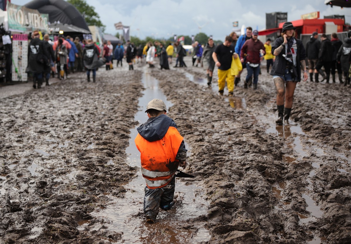 dpatopbilder - 01.08.2023, Schleswig-Holstein, Wacken: Metal-Fans sind auf dem schlammigen Festivalgel