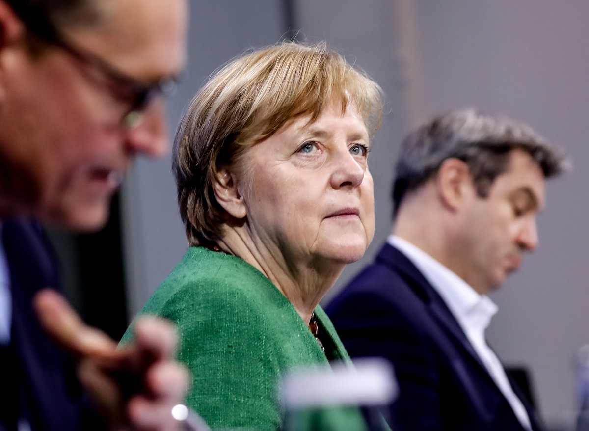 epa09090772 (L-R) Berlin's Mayor Michael Mueller, German Chancellor Angela Merkel and Premier of Bavaria Markus Soeder attend a press conference after a video conference with German State Premier ...