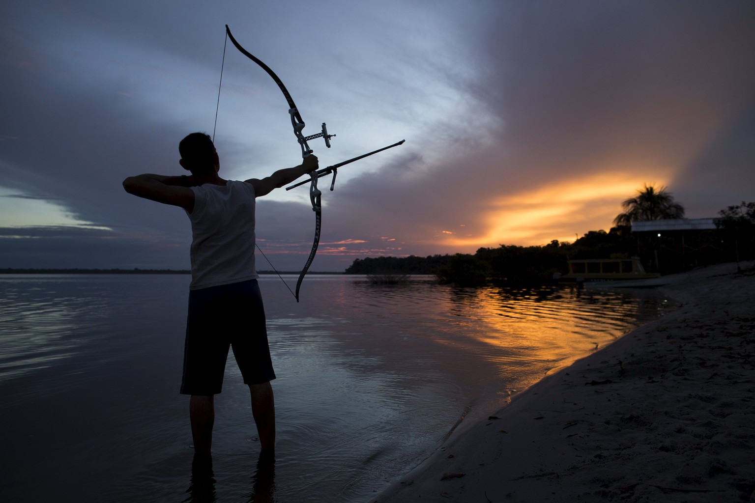 Kambeba Indian, Dream Braga, 18, poses for a picture during sunset on the banks of the Negro river at the village Tres Unidos, Amazon state, May 9, 2015. Dream Braga has been shooting fish with a bow  ...