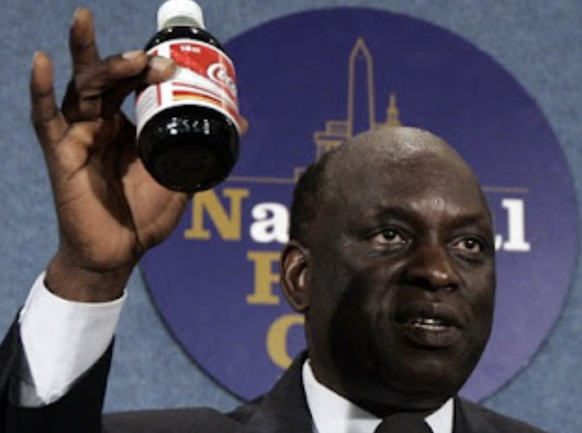 Threatening the West with a coke bottle: Ambassador John Ukec Lueth Ukec at the 2007 press conference.