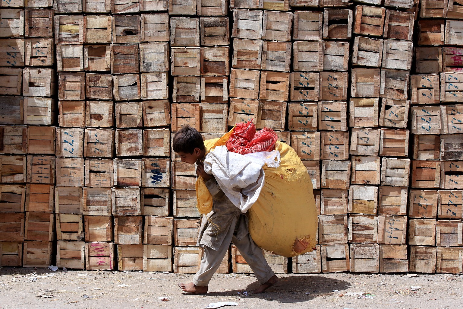 epa09264230 A Pakistani boy carries a sack of recycleable waste as the world observes the day against Child Labor, in Peshawar, Pakistan, 12 June 2021. World Day Against Child Labor is observed annual ...