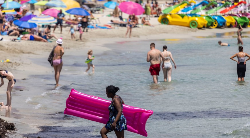 epa09333578 Tourists enjoy the sunny warm weather at Peguera beach in Calvia, Mallorca, Spain, 08 July 2021 (issued 09 July 2021). Germany has classified Spain as a COVID-19 risk area 09 July 2021, am ...