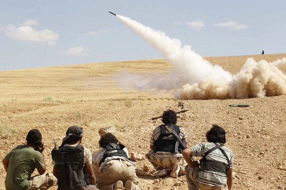 Soldaten der freien syrischen Armee feuern eine Rakete ab.