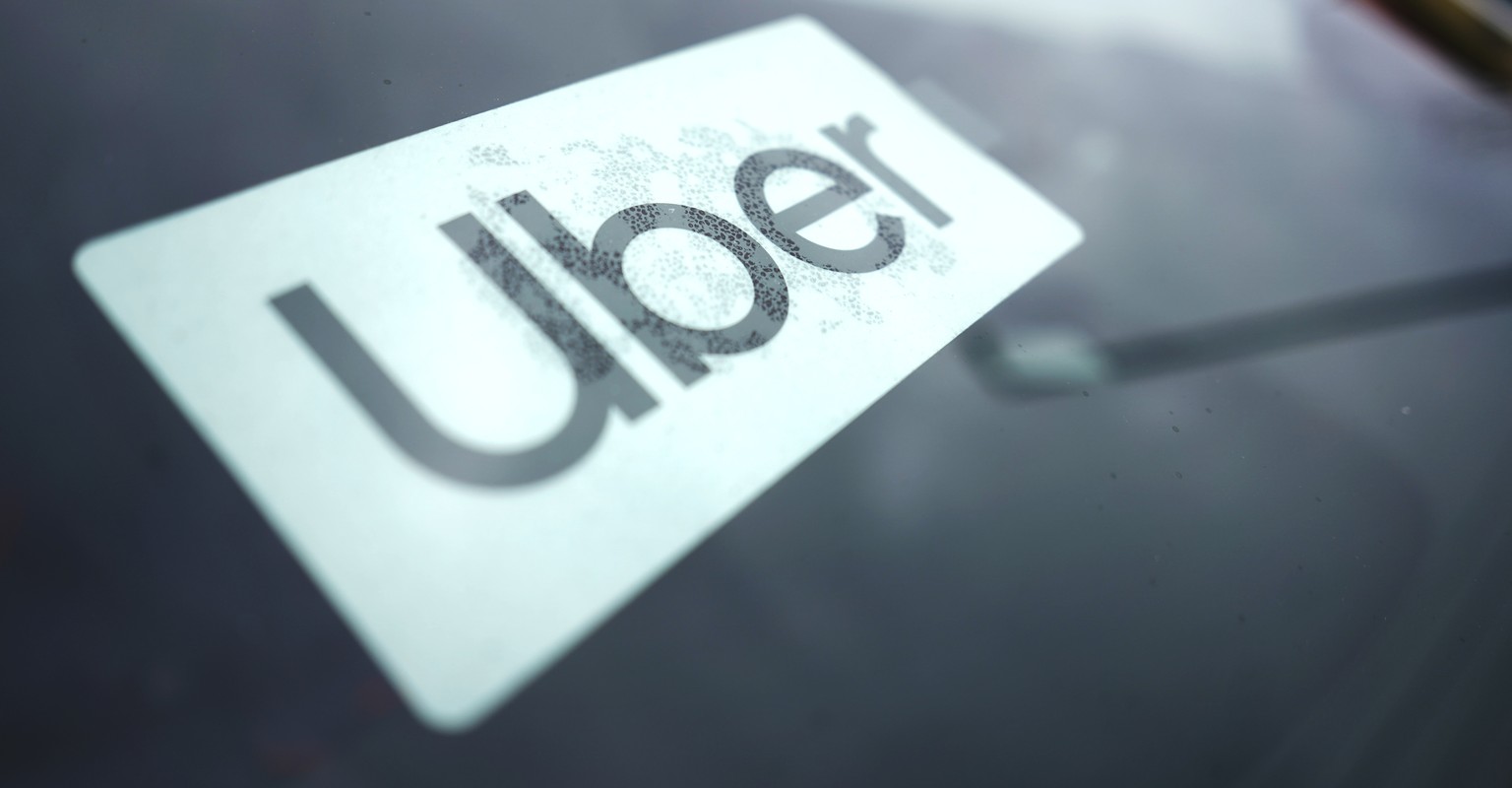 An Uber sign is displayed inside a car in Palatine, Ill., Thursday, Feb. 10, 2022. As Uber pushed into markets around the world, the ride-sharing service lobbied political leaders to relax labor and t ...