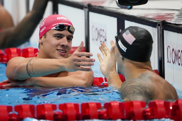 Noe Ponti, of Switzerland, swims in a men&#039;s 100-meter butterfly semifinal greets Caeleb Dressel, of United States, after a men&#039;s 100-meter butterfly semifinal at the 2020 Summer Olympics, Fr ...