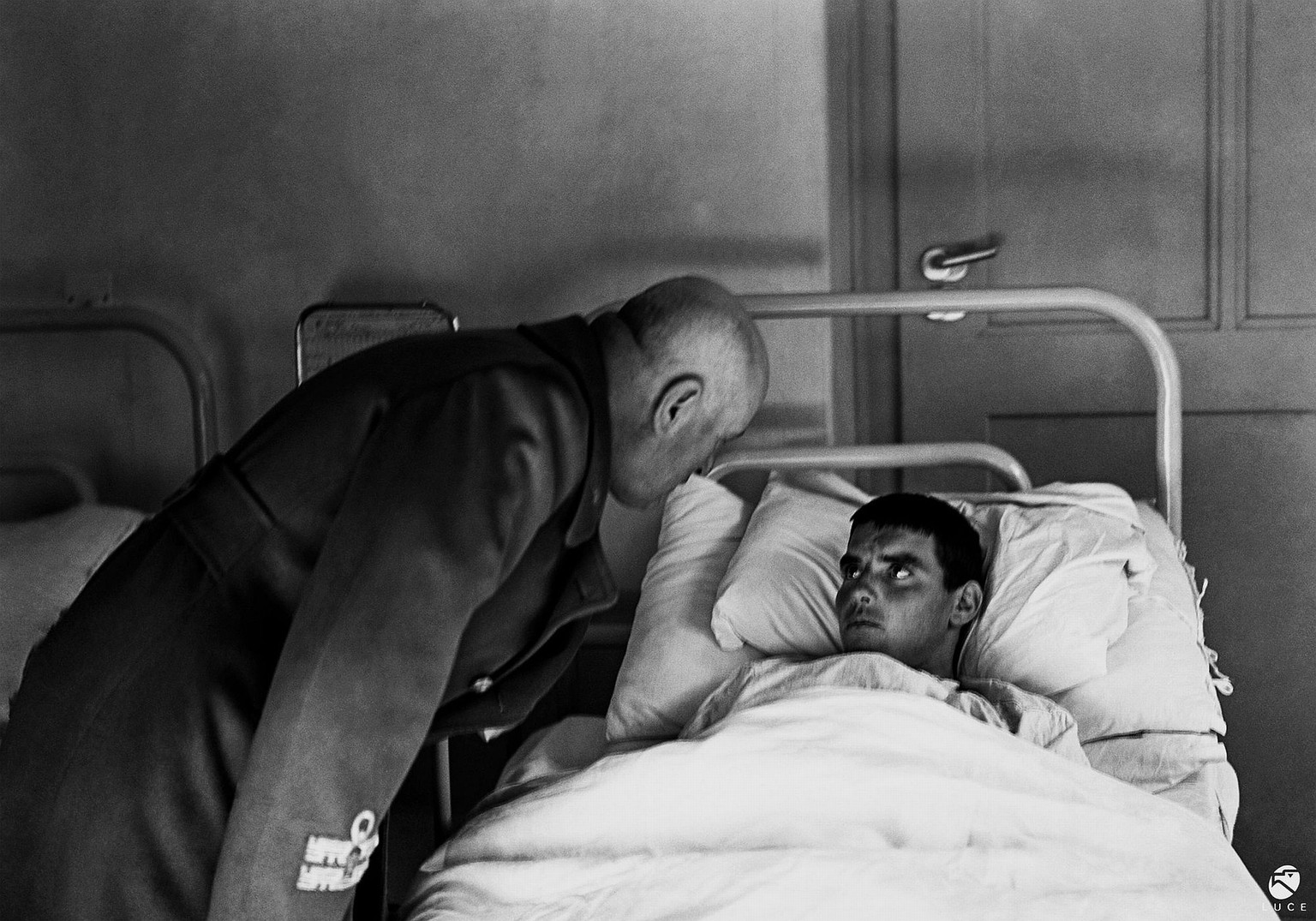Italian dictator Benito Mussolini visiting a wounded soldier during WW2. The photo was censored because of the soldier&#039;s terrified look. 1942.