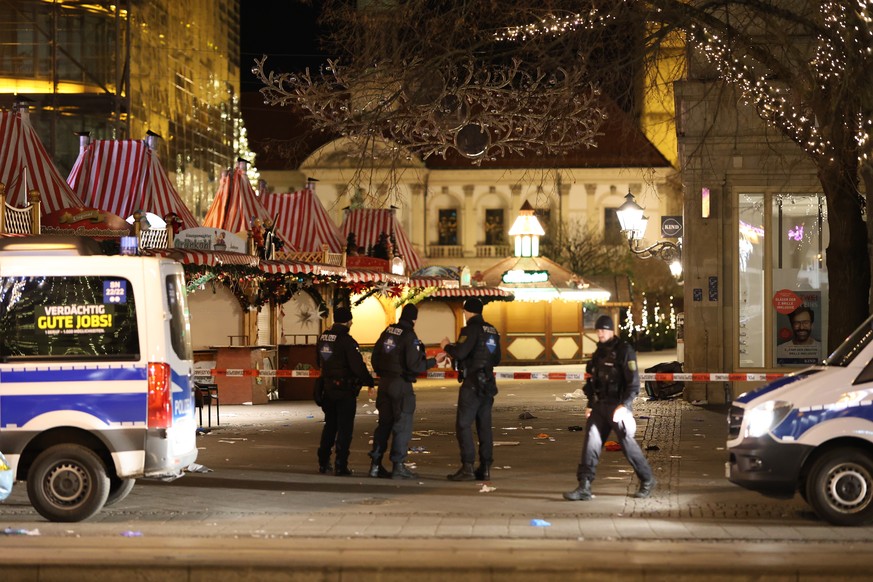 21.12.2024, Sachsen-Anhalt, Magdeburg: Einsatzfahrzeuge der Polizei stehen vor dem Weihnachtsmarkt in Magdeburg. Nach dem mutma�lichen Anschlag auf dem Magdeburger Weihnachtsmarkt laufen die Ermittlun ...