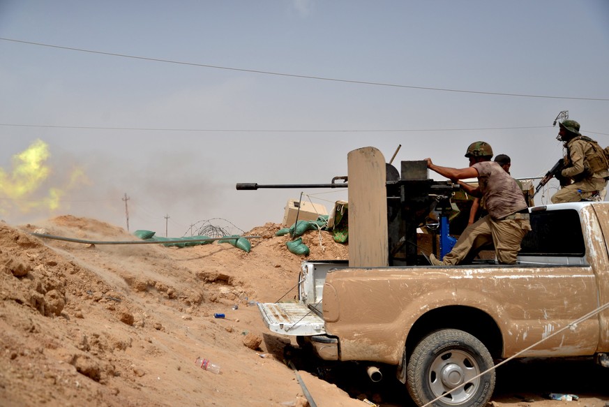 Soldaten im Irak schiessen auf Stellungen der IS-Milizen.