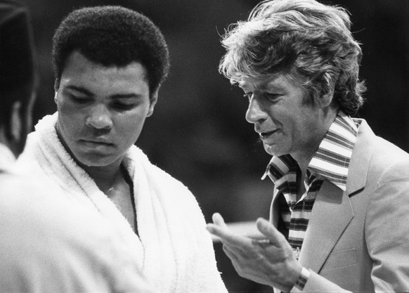 Rudi Carrell, hollaendischer Fernsehunterhalter, befragt den Schwergewichtsweltmeister Muhammad Ali, waerend einer Pause seines taeglichen Trainings, in Muenchen 19. Mai, 1976. (KEYSTONE/AP PHOTO/Diet ...