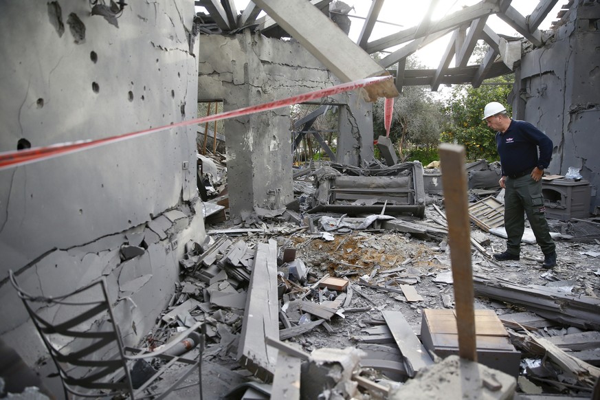 A police officer inspects the damage to a house hit by a rocket in Mishmeret, central Israel, Monday, March 25, 2019. An early morning rocket from the Gaza Strip struck a house in central Israel on Mo ...