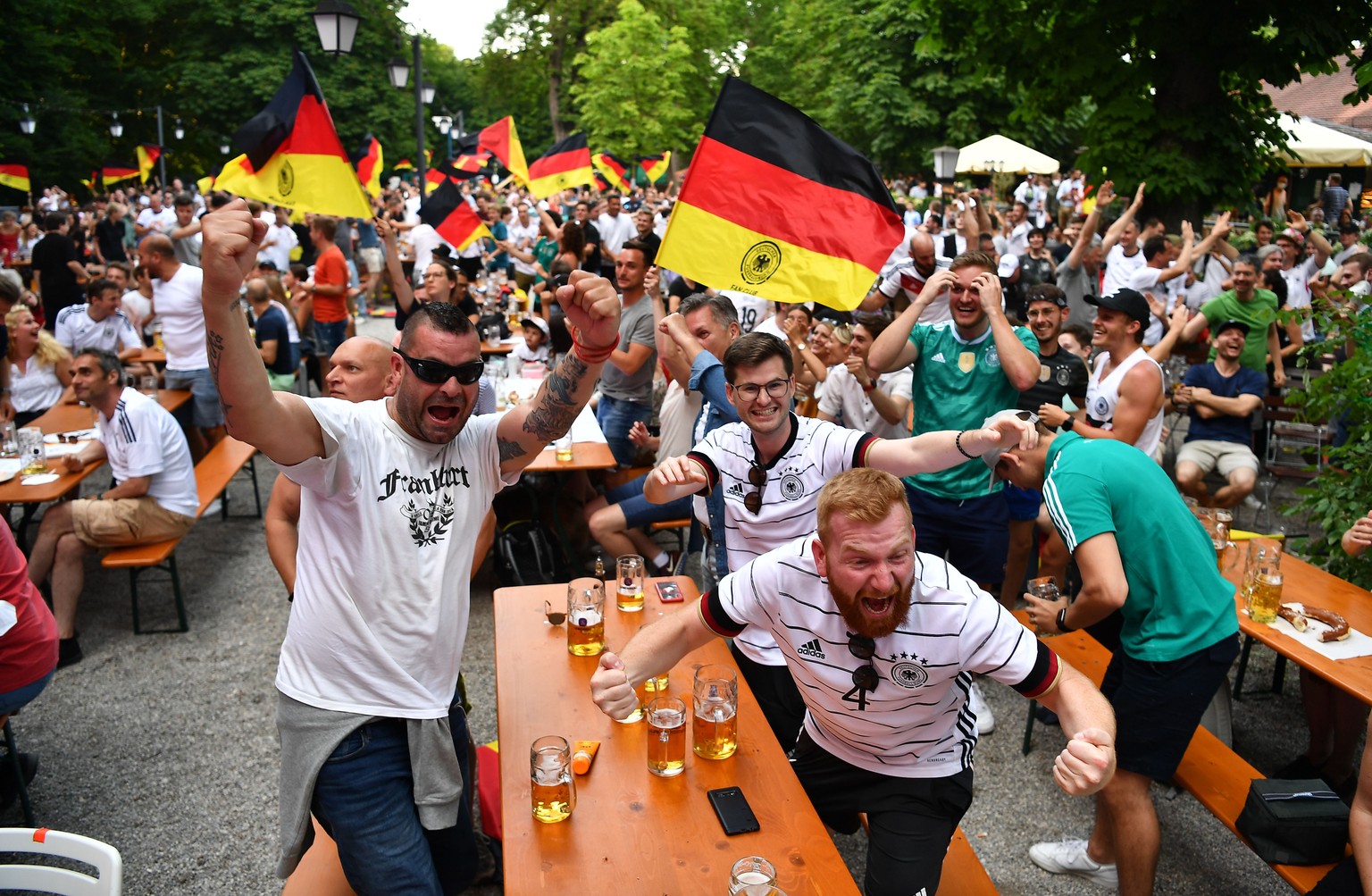 epa09286726 German Fans celebrate a goal at a beer garden during the UEFA EURO 2020 group F preliminary round soccer match between Portugal and Germany in Munich, Germany, 19 June 2021. EPA/LUKAS BART ...