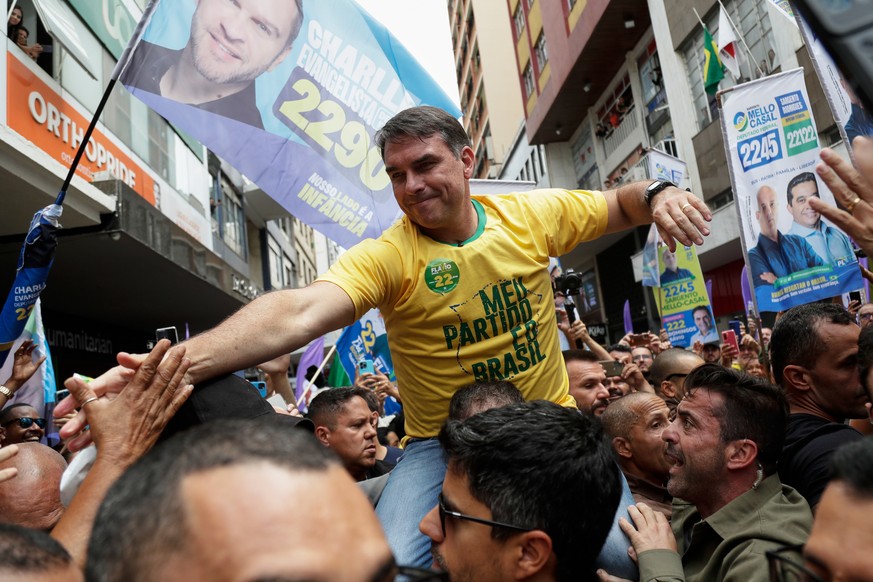 Presidential candidate Flavio Bolsonaro rides on a man's shoulders during his campaign rally at the site where his father, former President Jair Bolsonaro, was injured by a stabbing attack in 201 ...