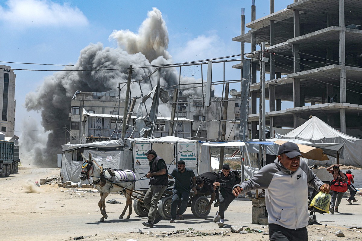 epa12127798 Palestinians run for cover as smoke rises following an Israeli airstrike west of Gaza City, in Gaza Strip, 23 May 2025. More than 53,700 Palestinians have been killed in the Gaza Strip, ac ...