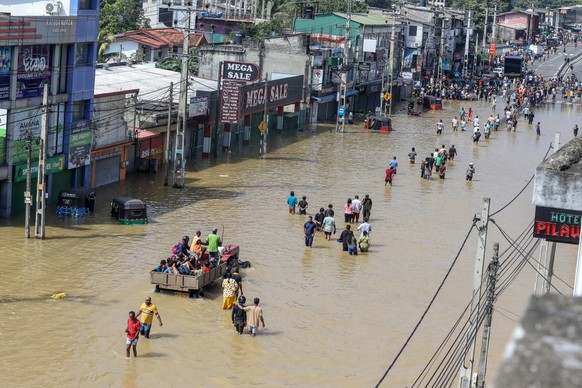 epa12559537 People wade through a flooded road after heavy rainfall in a suburb of Colombo, Sri Lanka, 30 November 2025. Many parts of the island have been inundated due to heavy rains. According to t ...