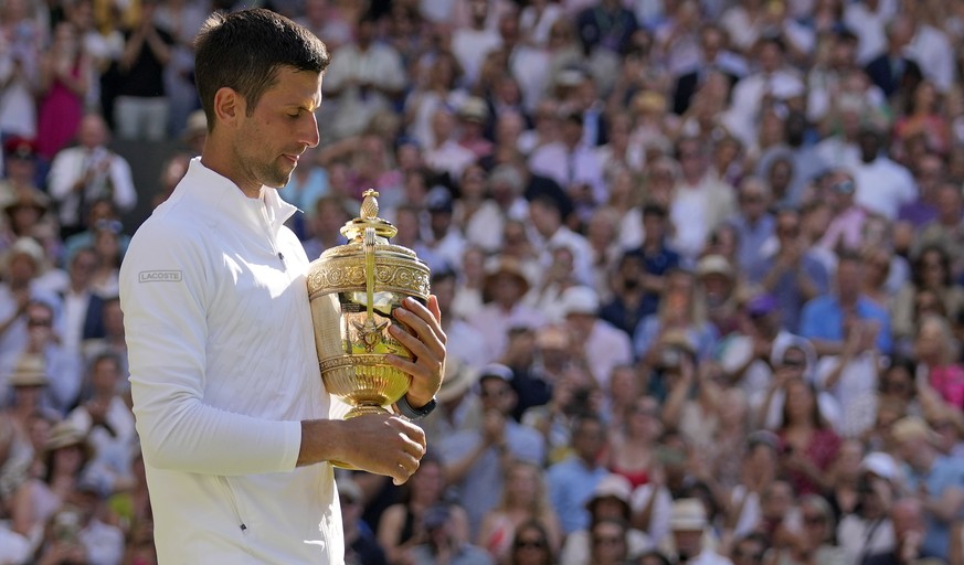 Serbia&#039;s Novak Djokovic holds the trophy as he celebrates after beating Australia&#039;s Nick Kyrgios to win the final of the men&#039;s singles on day fourteen of the Wimbledon tennis championsh ...