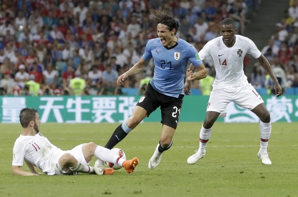 Uruguay&#039;s Edinson Cavani, center, challenges for the ball with Portugal&#039;s Bernardo Silva, left, during the round of 16 match between Uruguay and Portugal at the 2018 soccer World Cup at the  ...