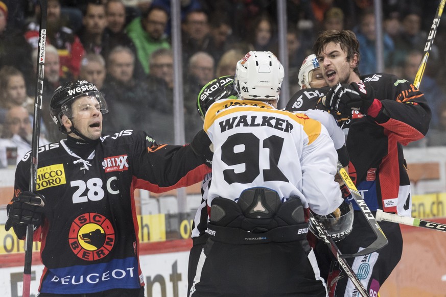 HC Lugano Stuermer Julian Walker, Mitte, laesst sich auf einen Faustkampf ein gegen SC Bern Stuermer Alain Berger, rechts, und Martin Pluess, im Eishockey Meisterschaftsspiel der National League A zwi ...