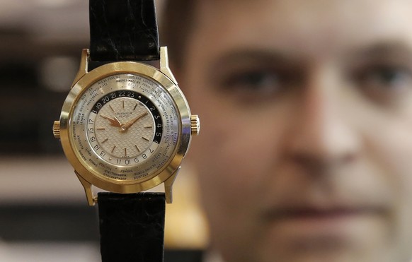 Sam Hines, International Head of Watches at Philipps displays a 1954 pink gold world time wristwatch with two crowns and two-tone dial by Patek Philippe during a media preview for a watch auction in H ...