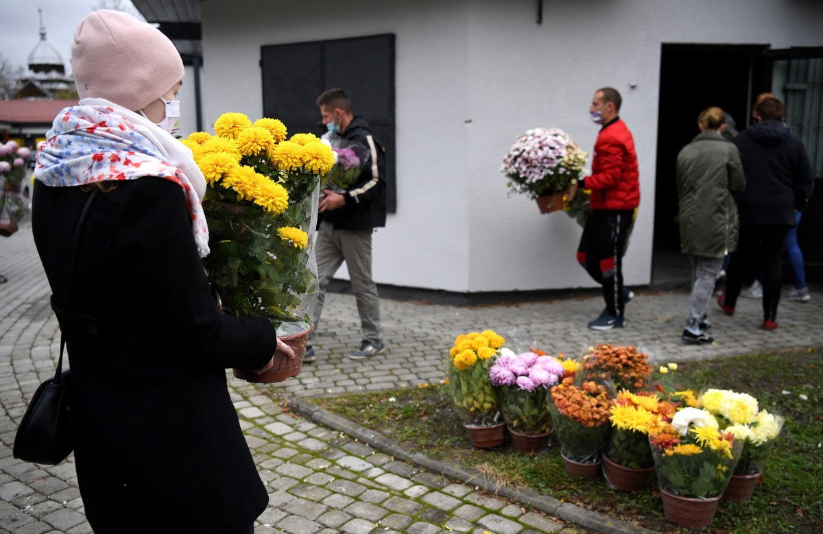 epa08804224 Volunteers distribute chrysanthemums to help vendors who were unable to sell their flowers on All Saints' Day due to the COVID-19 restrictions, in Fredropol, Poland, 07 November 2020. ...