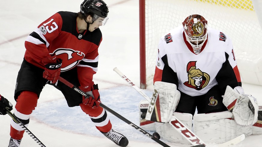 Ottawa Senators goalie Mike Condon (1) blocks a shot by New Jersey Devils center Nico Hischier (13), of Switzerland, during the third period of an NHL hockey game, Friday, Oct. 27, 2017, in Newark, N. ...