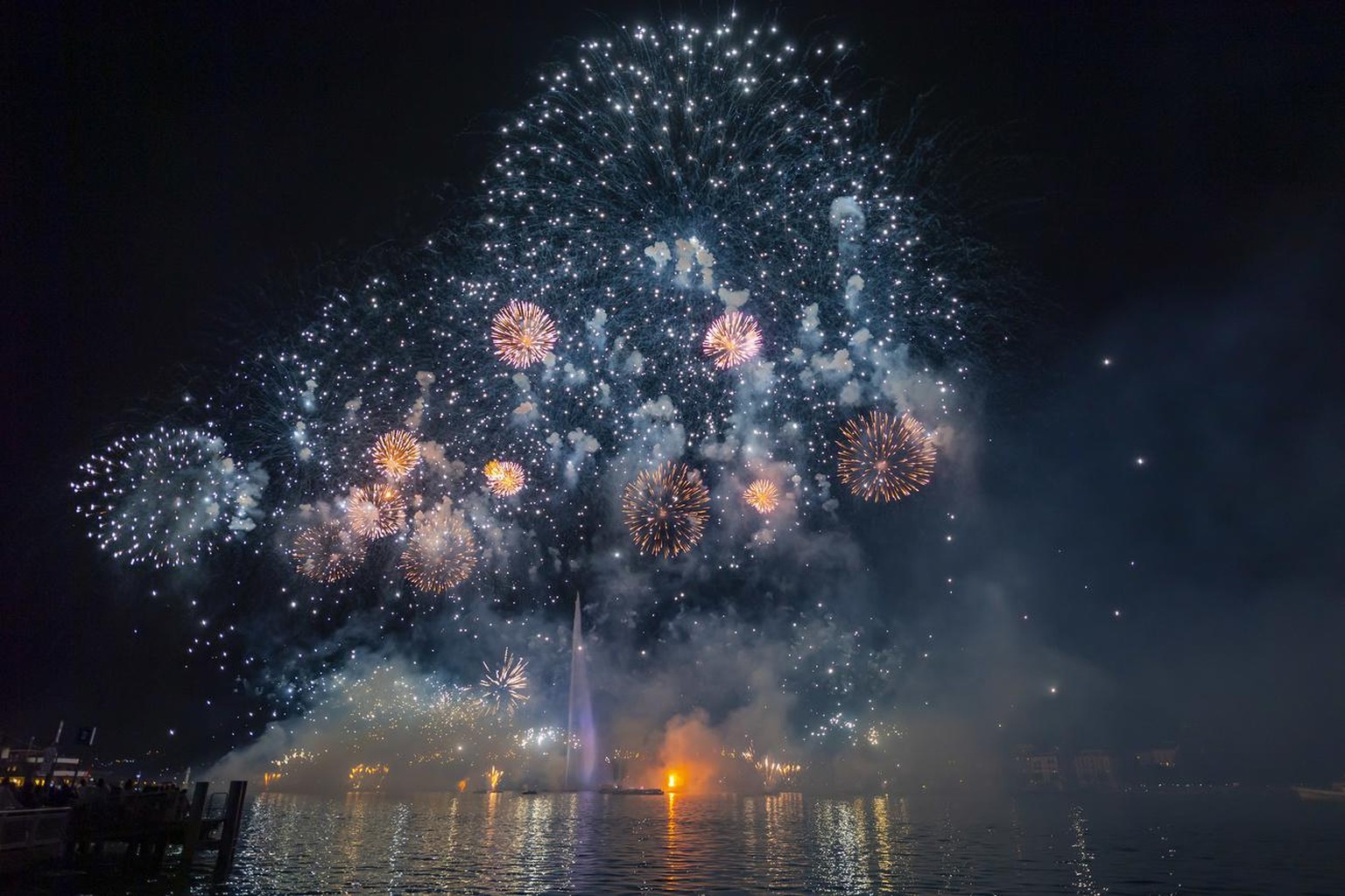 Fireworks illuminate the sky in bay of Geneva with the famous water fountain &quot;Le Jet d&#039;Eau&quot;, in Geneva, Switzerland, Saturday, August 10, 2019. (KEYSTONE/Martial Trezzini)