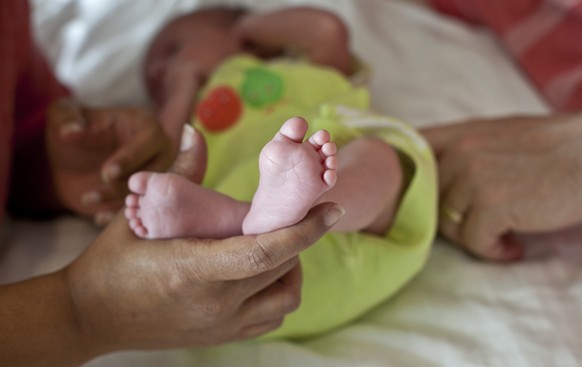 In this Nov. 5, 2015 photo, a couple from Britain whose baby was born on Oct. 17 by a surrogate pose their baby for a photo in Anand, India. For 15 years the couple were unable to get pregnant and tur ...