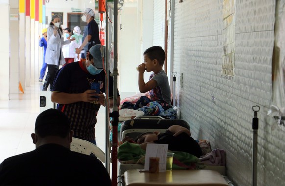 epa10467121 A father accompanies his son as he is treated in the hallway of the children's hospital in Santa Cruz, Bolivia, February 14, 2023. Hospitals in eastern Santa Cruz, the largest region in ...