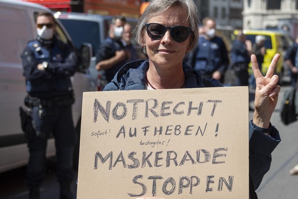 Eine Frau haelt ein Plakat an einer Mahnwache fuer die Wahrheitsfindung und die Einhaltung der Grundrechte der Organisation Baselwach auf dem Marktplatz in Basel, am Samstag, 16. Mai 2020. (KEYSTONE/G ...