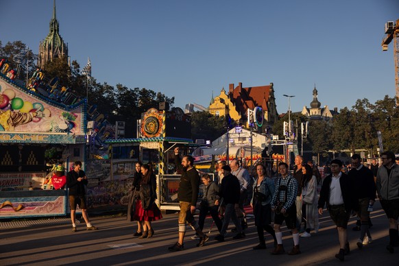 epa12420791 Visitors on the Oktoberfest grounds after its reopening in Munich, Germany, 01 October 2025. The Oktoberfest grounds in Munich will remain closed until at least 5 p.m. local time on 01 Oct ...