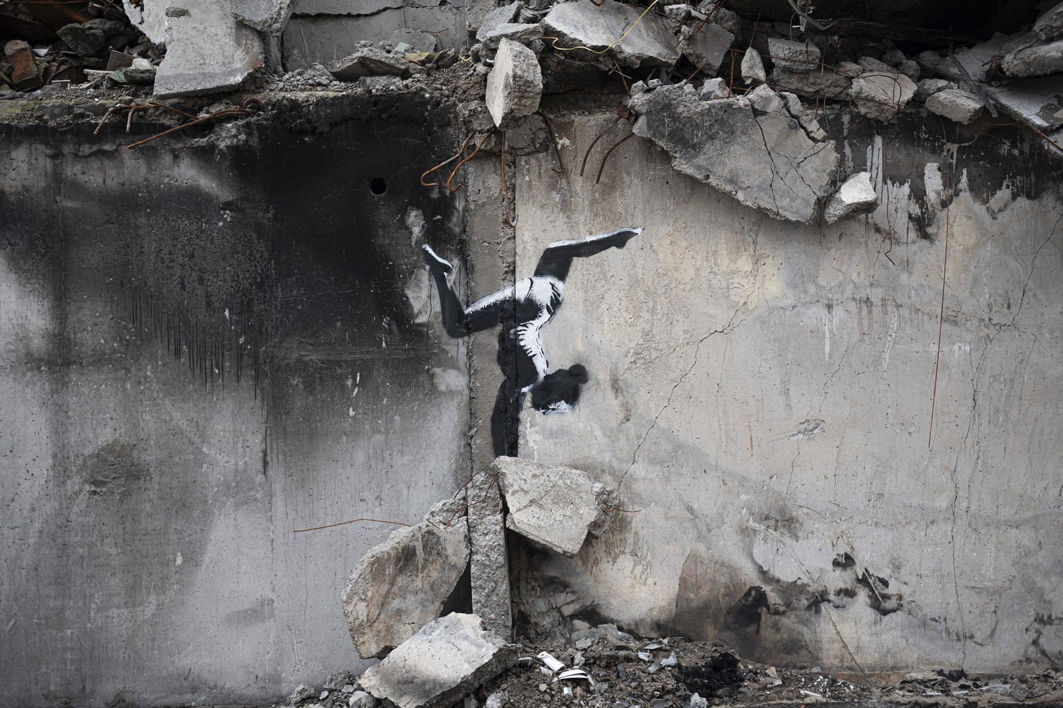 An artwork by British street artist Banksy is seen on a building destroyed by fighting in Borodyanka, Kyiv region, Ukraine, Sunday, Nov. 13, 2022. (AP Photo/Andrew Kravchenko)