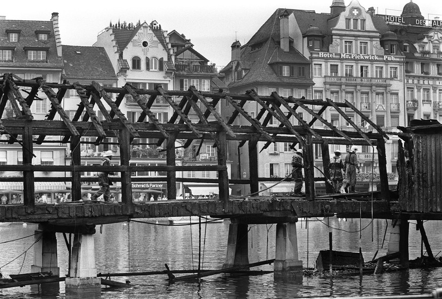 <strong>18. August 1993:</strong>&nbsp;Feuerwehrleute verrichten Aufräumarbeiten nach dem Brand der Kapellbrücke.&nbsp;<br data-editable="remove">