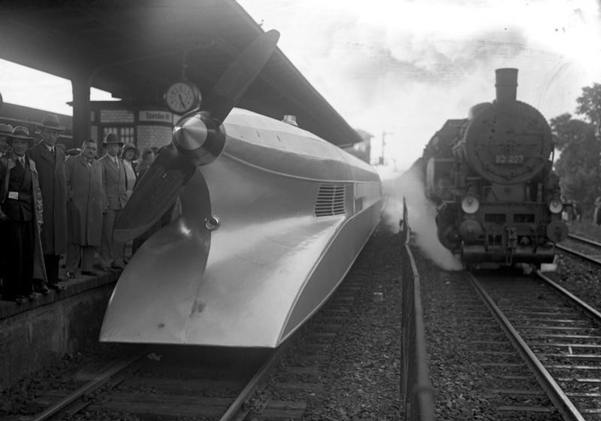 Der Schienen-Zeppelin in Berlin!
Technik von gestern und heute. Ein Schnellzug auf dem Wege nach Hamburg passiert auf dem Spandauer Hauptbahnhof den soeben eingetroffenen Schienenzeppelin.