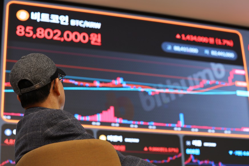 epa11187936 A client looks at an electronic signboard at a cryptocurrency exchange in Seoul, showing the price of bitcoin rising to 85.80 million won (64,303 dollars) during a trading session, South K ...