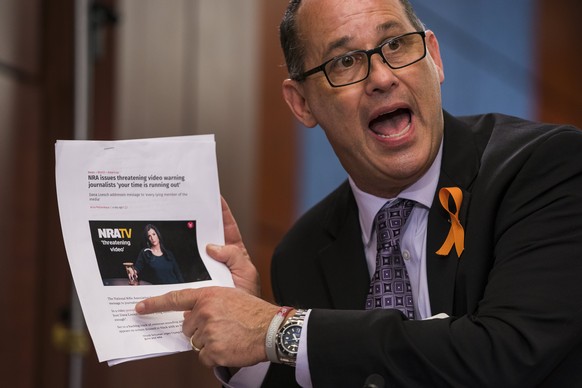 epa06587981 Fred Guttenberg, father of Jaime Guttenberg, age 14, who was killed at Marjory Stoneman Douglas High School, holds a recent NRA advertisement that threatens members of the media and politi ...