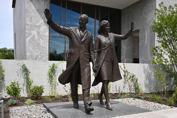 epa13014806 A bronze sculpture depicting former US President Barack Obama and First Lady Michelle Obama waving to crowds is featured outside the entrance of the 225-foot Museum Building tower on the 1 ...