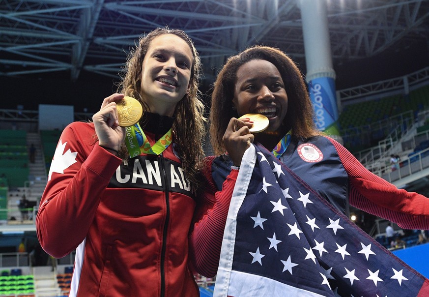 Canada&#039;s Penny Oleksiak, left, and United States&#039; Simone Manuel celebrate their tie for gold in the women&#039;s 100-meter freestyle during the Olympic Summer Games in Rio de Janeiro, Brazil ...